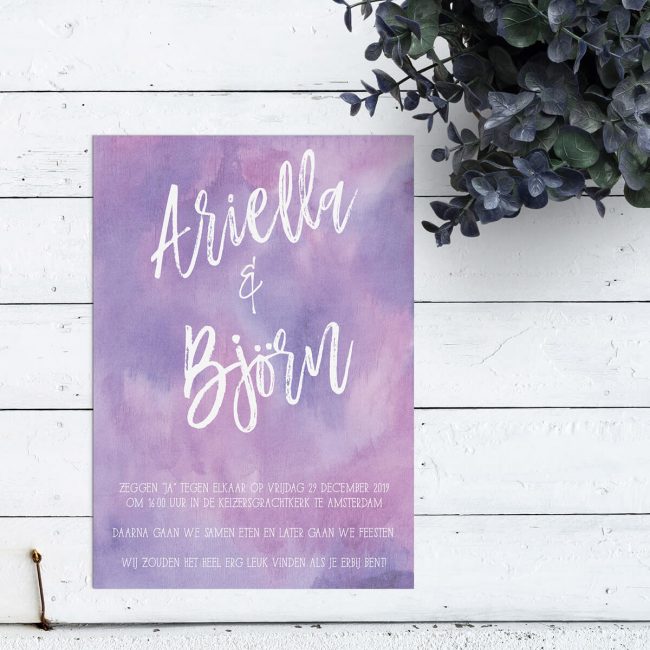 Eenvoudige trouwkaart met een achtergrond volledig in waterverf in paarse tinten. Een bijzonder sierlijk lettertype voor jullie namen, in grote letters.