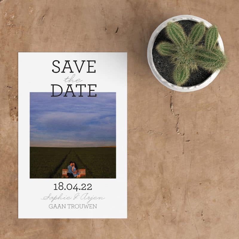 Save the date kaart Statement, daar zeg je iets mee. Een modern vormgegeven kaartje, met de woorden Save the date, in mooie eigentijdse lettertypes, die iets over de foto heen steken.