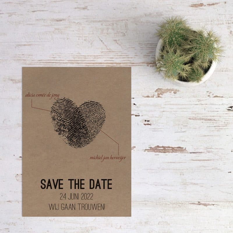 Twee vingerafdrukken die samen een hart vormen, save the date kaart Vingerafdrukken op kraftpapier presenteert de twee die samen dit hart hebben gevormd.