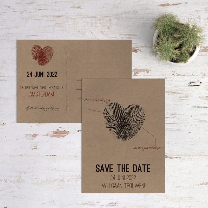 Twee vingerafdrukken die samen een hart vormen, save the date kaart Vingerafdrukken op kraftpapier presenteert de twee die samen dit hart hebben gevormd.